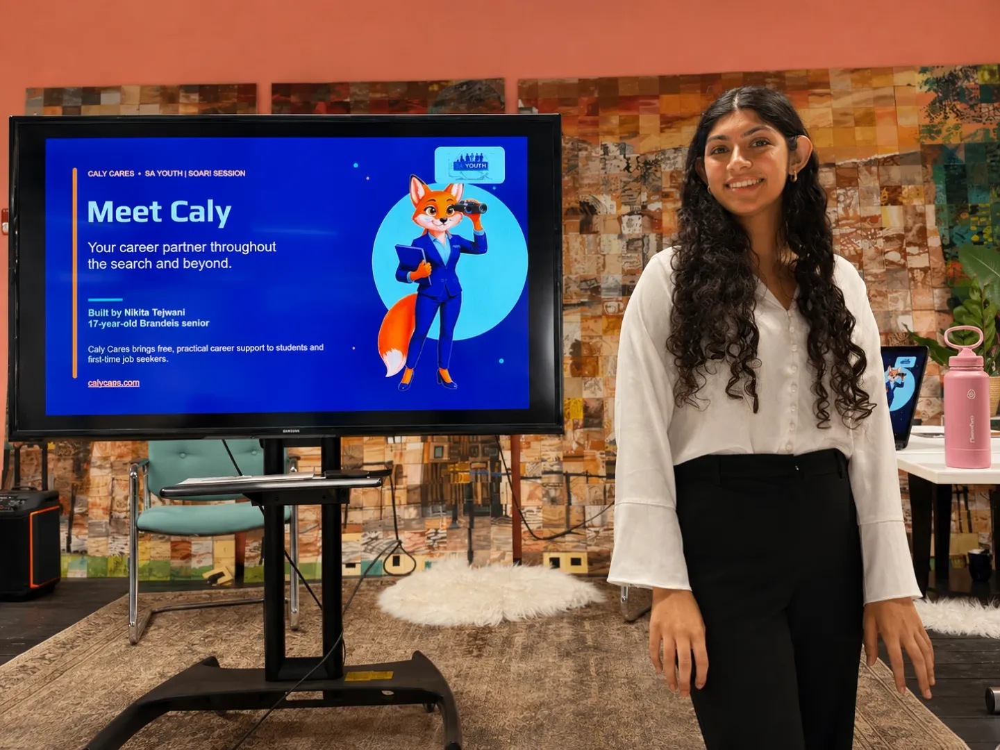 Nikita Tejwani standing beside a screen reading “Meet Caly — your career partner throughout the search and beyond” while leading a Caly Cares session for the SA Youth SOAR program.